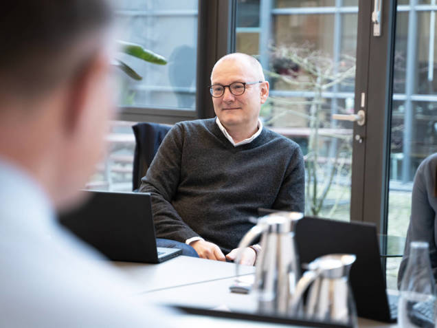 Business System Consultant siddende i et forretningsmøde