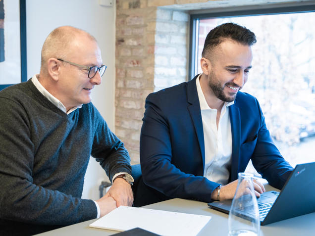 To medarbejdere holder møde omkring en kommende asset management løsning